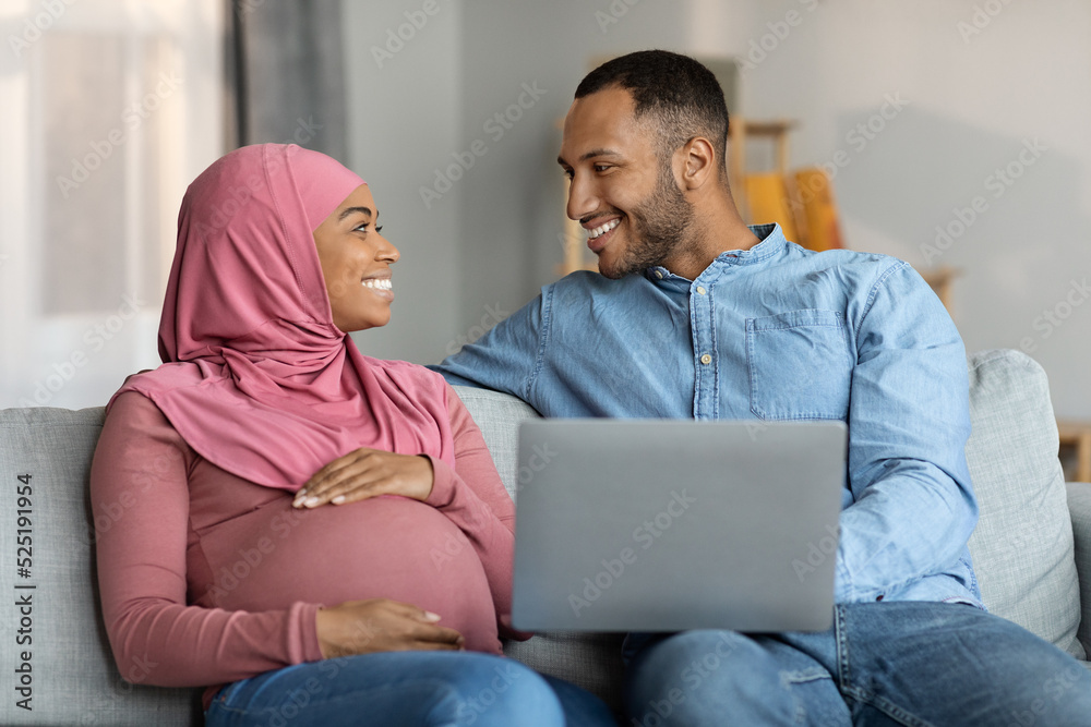 Pregnant Black Muslim Couple Resting With Laptop Computer At Home Pregnant Black Muslim Couple Resting With Laptop Computer At Home