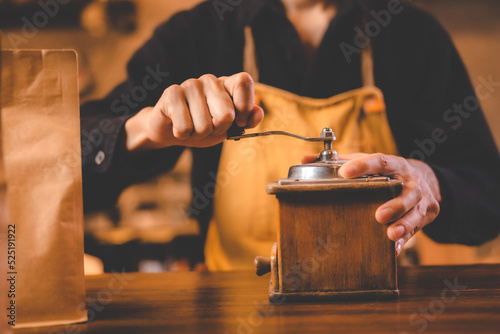 barista holding hand grinde...