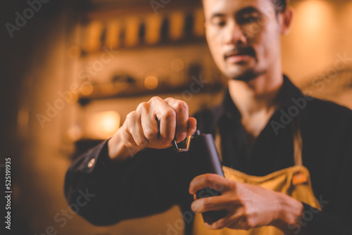 barista holding hand grinde...