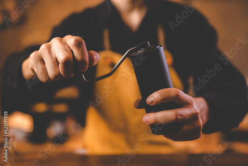 barista holding hand grinde...