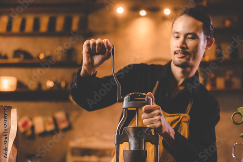 barista holding hand grinde...