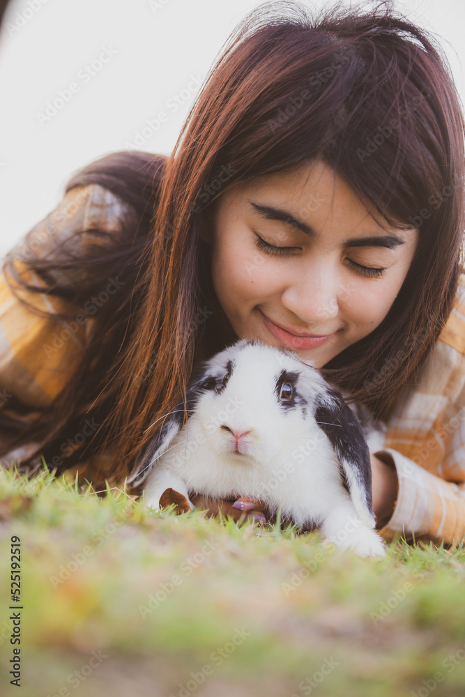 beautiful pretty portrait of young Asian woman person with cute rabbit in pet and animal care concept, happy female holding bunny at nature outdoor field with friendship, easter concept beautiful pretty portrait of young Asian woman person with cute rabbit in pet and animal care concept, happy female holding bunny at nature outdoor field with friendship, easter concept