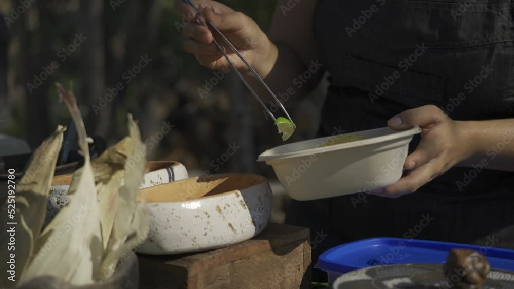 Mano con pinza preparando comida mexicana al aire libre 