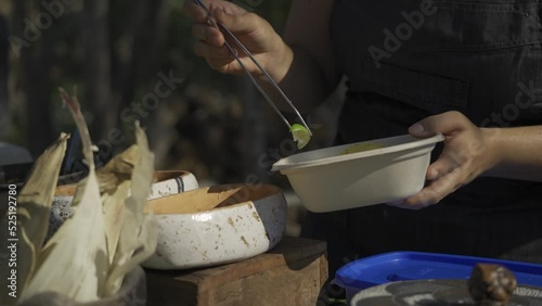 Mano con pinza preparando comida mexicana al aire libre  photo