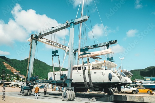 Boat Crane in the Caribbean lifting a catamaran sailing boat 