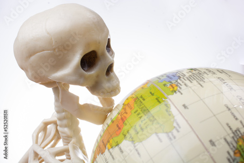 Skeleton with a globe in hands photo