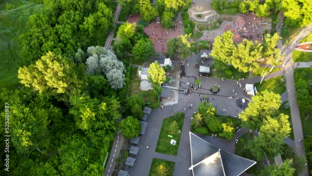 Aerial sunset look down fpv view on water spring in green summer Kharkiv city center popular recreation park Sarzhyn Yar. Botanical garden with water spring and playground