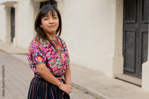 Hispanic woman with typical Mayan costume smiling at the camera - Happy Hispanic young woman in the village in Latin America