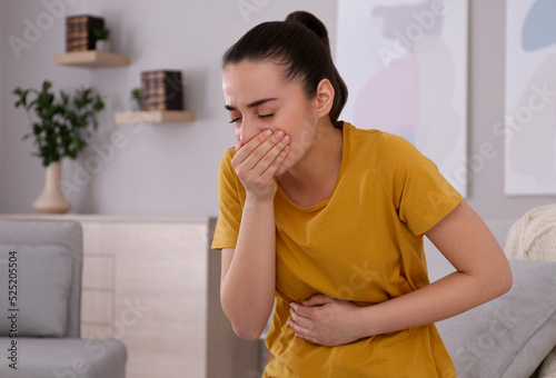 Young woman suffering from nausea at home. Food poisoning photo