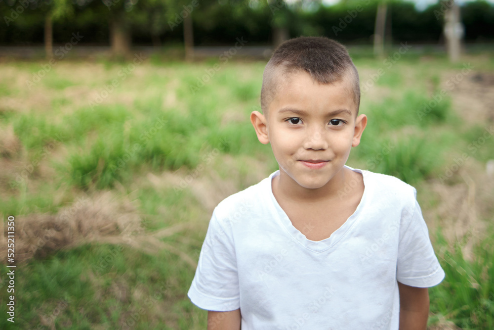 peasant boy smiling looking at the camera in grass field peasant boy smiling looking at the camera in grass field
