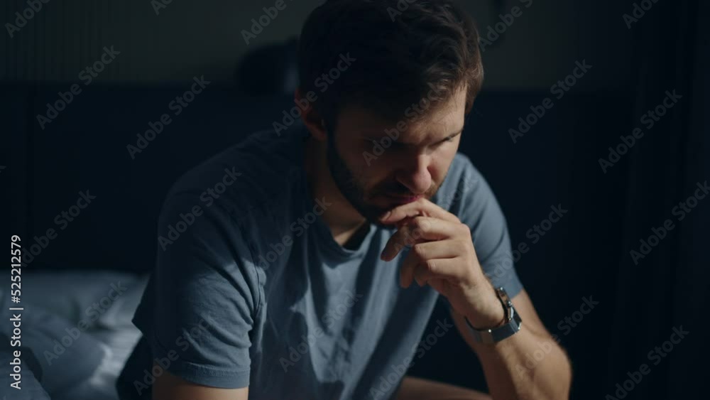 Upset caucasian man sitting on the bed, thinking about problem, breakup. Upset sick man sitting on bed, taking medication to recover from illness.Financial problems stress at work