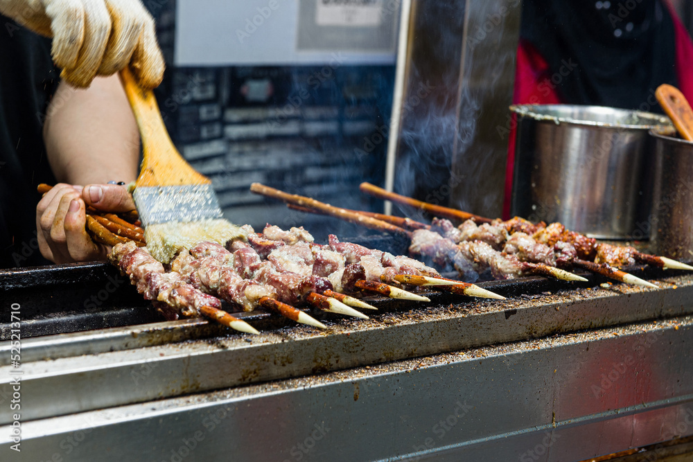 Marinated shashlik preparing on a barbecue grill over charcoal. Shashlyk (skewered meat) was originally made of lamb.