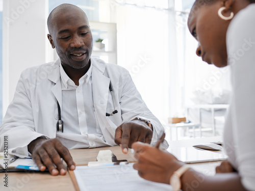 Doctor, patient and signing insurance paper while talking and pointing at consent form in clinic, hospital and health center. Consulting, medical checkup and medicine research with healthcare worker photo
