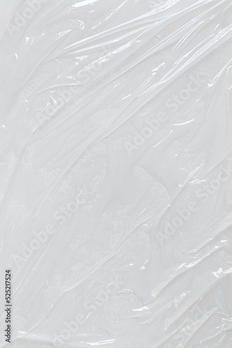 White transparent crumpled and creased plastic poster texture background. wet plastic wrap on the white background