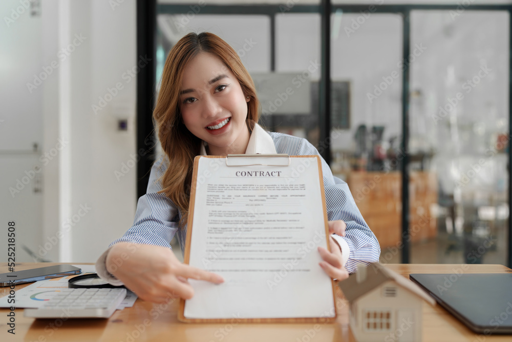 Business woman or agent pointing and signing agreement for buying house. Bank manager concept Business woman or agent pointing and signing agreement for buying house. Bank manager concept