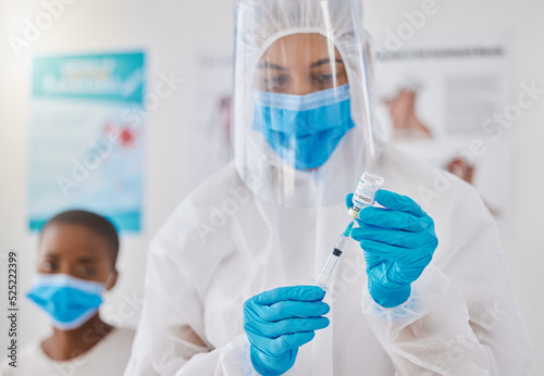 Vaccine, injection and medicine cure for covid, monkeypox and ebola with doctor, healthcare or medical professional. Frontline worker in hazmat suit getting ready to inject clinic or hospital patient photo