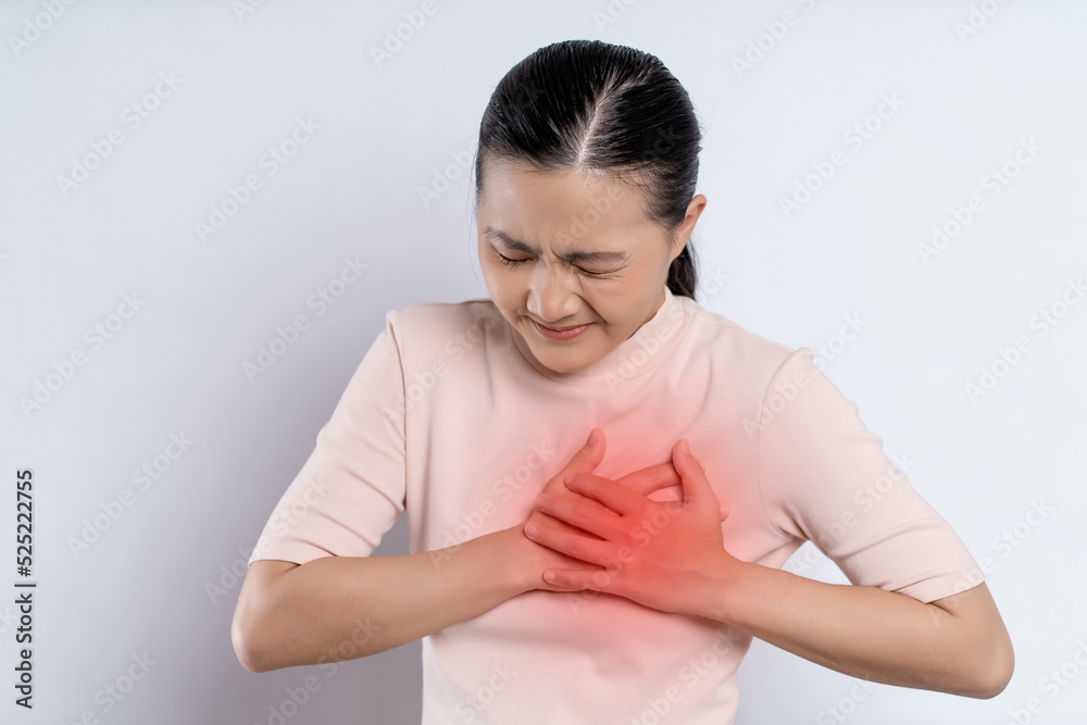 Asian woman having chest pain holding hands on chest with red spot. Asian woman having chest pain holding hands on chest with red spot.