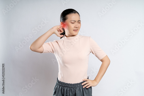 Woman itching putting a finger into her ear with red point.