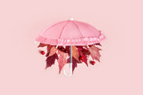 Autumn leaves fall from pink umbrella on pink pastel background. Hello Autumn creative concept