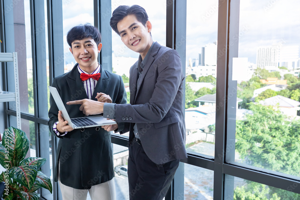 Fototapeta premium Company executive Young Asian businessman and coaching personal secretary assistant Homosexual businessman LGBT partners while working together with laptop computer and strategy in business in office