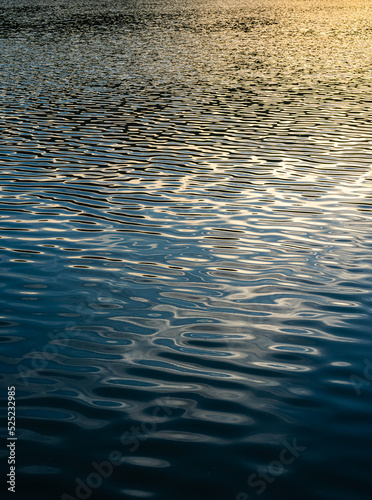 ฺBeautiful Reflected the sun rays hitting the water surface river is waves the sea surface before sunset natural background. © Thinapob