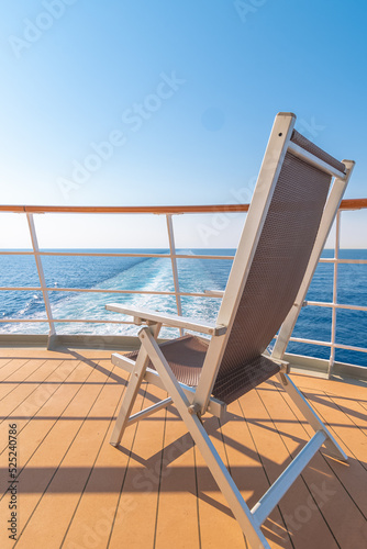 Vue d'une chaise longue sur le pont d'un navire de croisière dans le sillage d'un navire de croisière. Vue depuis la poupe du navire. 