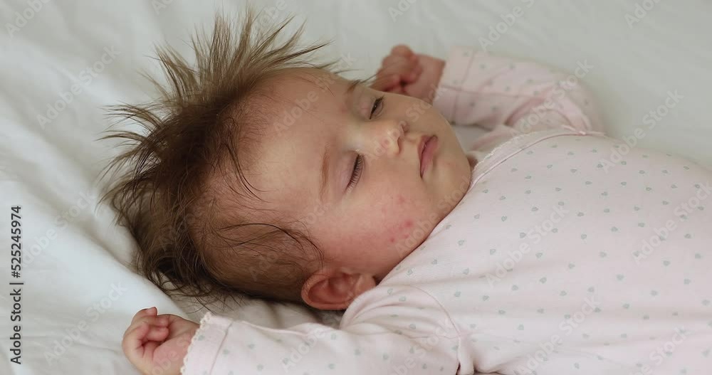 Newborn girl in pink bodysuit falls asleep in bed, close up. Cute calm baby sleeps lying alone looks carefree. Babyhood, healthy day or night rest for child growth, Alpha generation offspring concept Newborn girl in pink bodysuit falls asleep in bed, close up. Cute calm baby sleeps lying alone looks carefree. Babyhood, healthy day or night rest for child growth, Alpha generation offspring concept