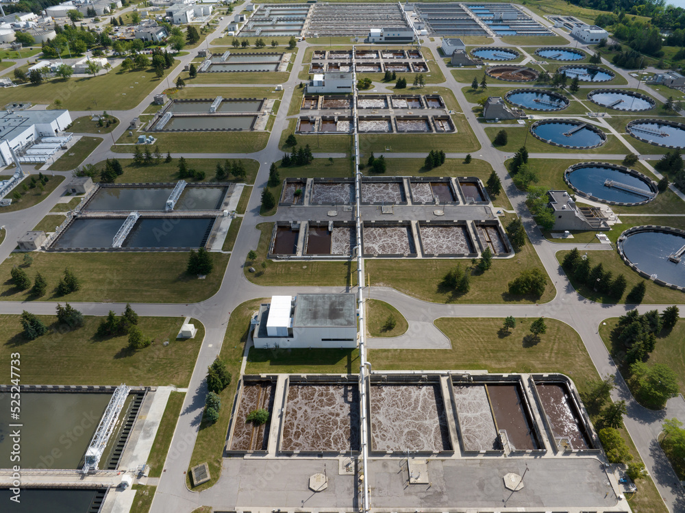 A high-angle aerial view above a large, vast water treatment plant on a sunny day.