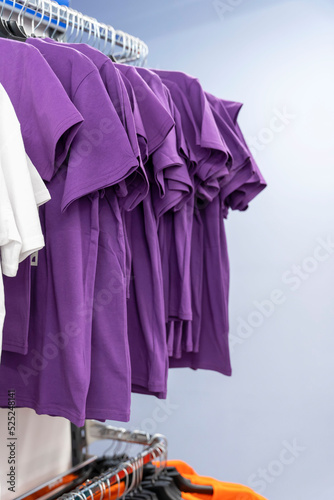 Close up of Colorful t-shirts on hangers, apparel background