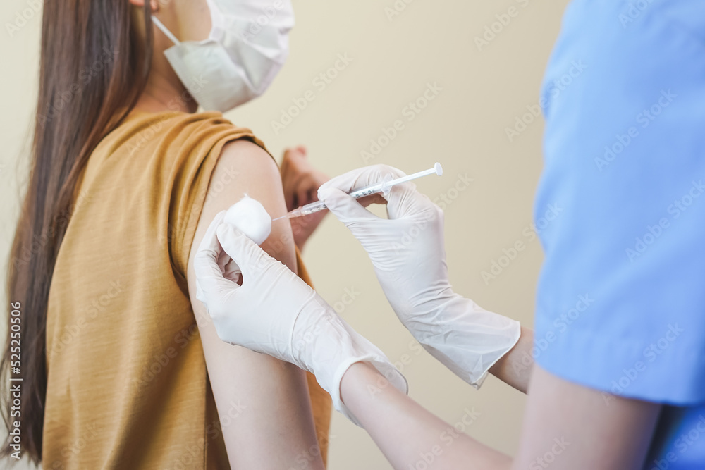 Covid-19,coronavirus hand of young woman nurse,doctor giving syringe vaccine, inject shot to asian arm's patient. Vaccination, immunization or disease prevention against flu or virus pandemic concept. Covid-19,coronavirus hand of young woman nurse,doctor giving syringe vaccine, inject shot to asian arm's patient. Vaccination, immunization or disease prevention against flu or virus pandemic concept.