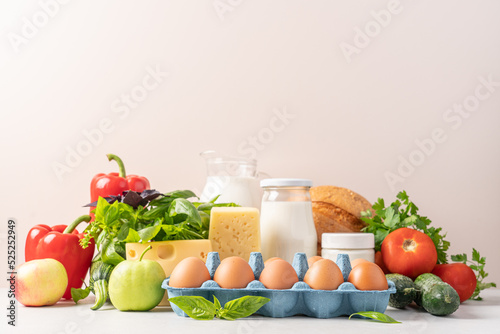 Groceries shopping or food delivery concept. Close up view of eggs, dairy products, vegetables, fruits, bread. Healthy eating photo