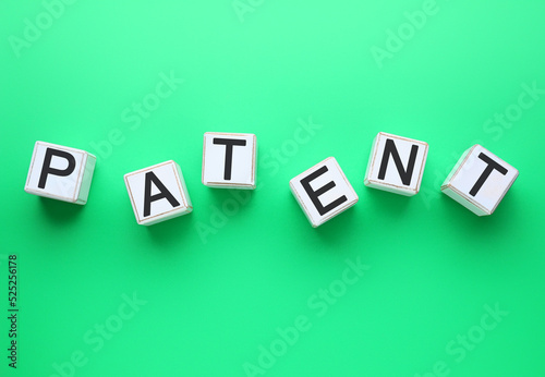 White cubes with word PATENT on green background photo