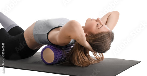 Young woman training with foam roller on white background