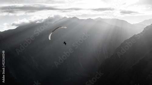 A paraglider on the sunset in the mountains, black and white