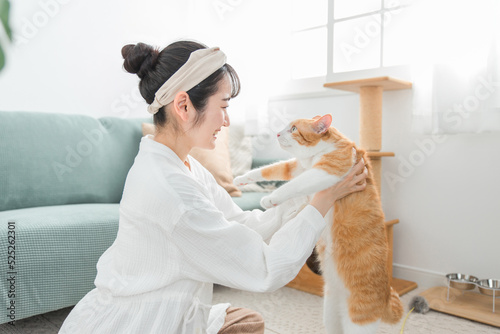 猫を抱っこして健康チェックをする女性
