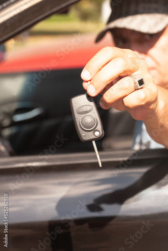 Car key in a man's hand with car. © yurchello108