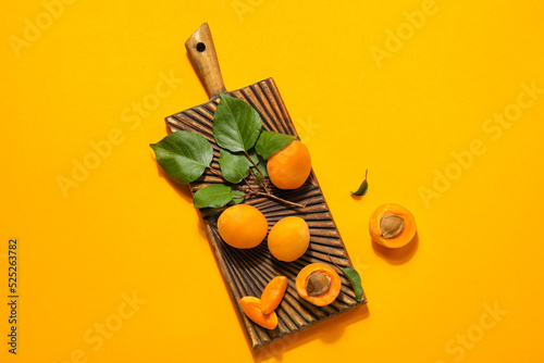 Wooden board with ripe apri...