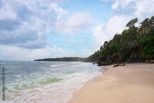 Beautiful tropiical landscape. Beach with sand, rocks and blue cloudy sky. photo