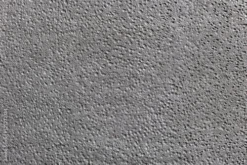 Textured background in silver gray color. The surface is dotted with small craters.