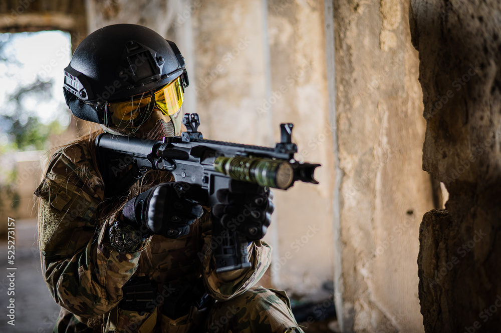 A woman in an army uniform shoots a firearm in an abandoned building. A woman in an army uniform shoots a firearm in an abandoned building.