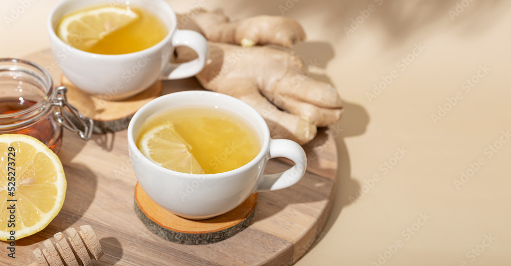 Cup of hot tea with ginger, honey and lemon on the beige background web banner with copy space for text Cup of hot tea with ginger, honey and lemon on the beige background web banner with copy space for text