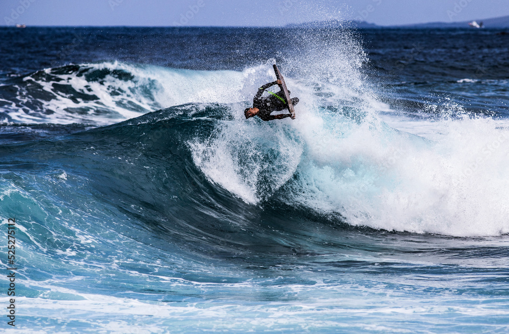 PUERTO DE SANTIAGO, TENERIFE - JUNE 2022: surfer riding the waves in Tenerife PUERTO DE SANTIAGO, TENERIFE - JUNE 2022: surfer riding the waves in Tenerife