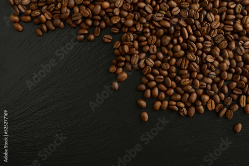 Roasted coffee beans on a black background. Beautiful coffee background. Coffee beans on a black stone table