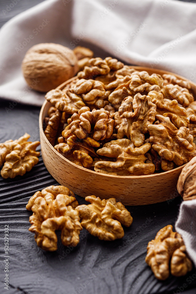 dried walnuts on a black rustic wooden background dried walnuts on a black rustic wooden background
