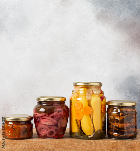 Preserving vegetables for the winter, canned vegetables in jars on a light background, pickled or fermented vegetables, copy space