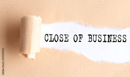 The text CLOSE OF BUSINESS appears on torn paper on white background.