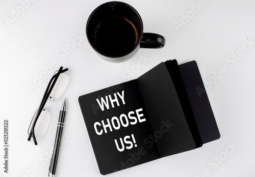 WHY CHOOSE US written text in small black notebook with coffee , pen and glasess on white background. Black-white style photo