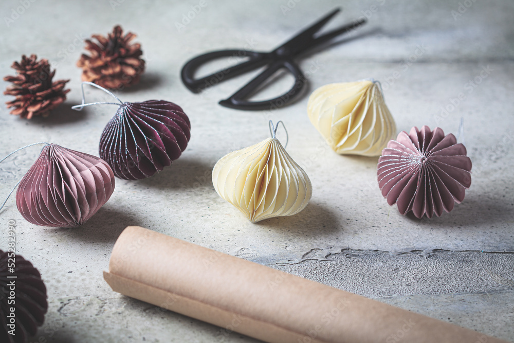 Paper handmade Christmas tree balls of different colors on gray background. Eco friendly, zero waste, holiday decoration. Paper handmade Christmas tree balls of different colors on gray background. Eco friendly, zero waste, holiday decoration.