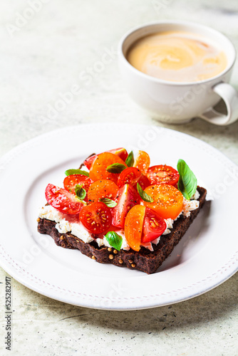 Rye toast with cream cheese, tomatoes and basil. Healthy breakfast recipe.