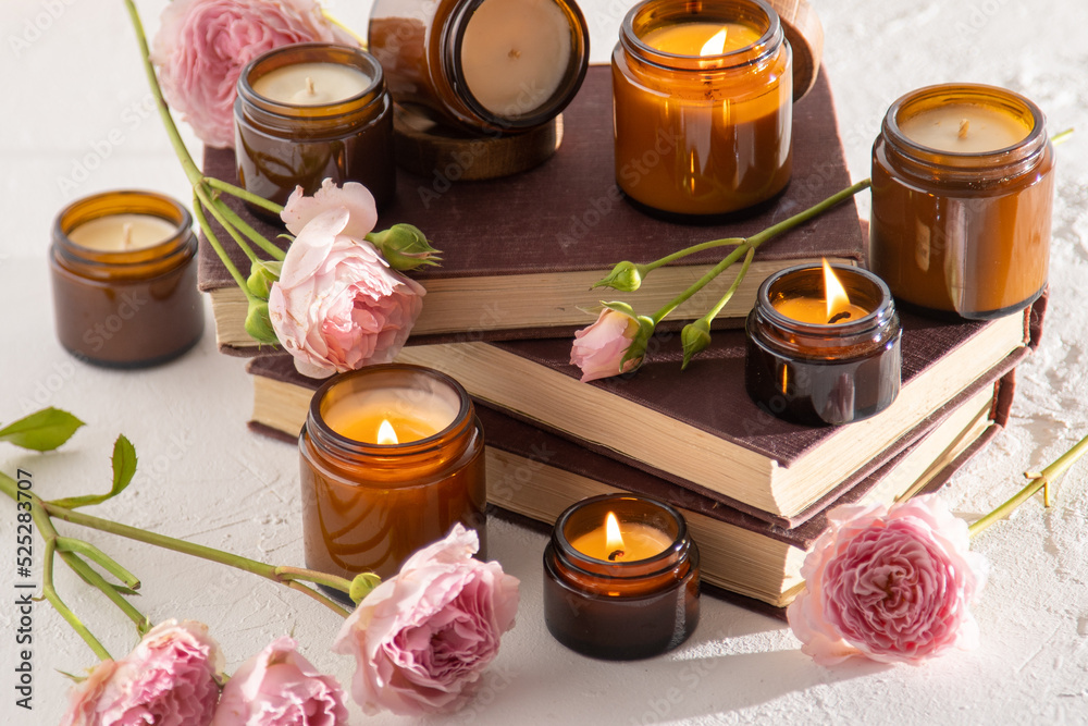A set of different aroma candles in brown glass jars. Scented handmade candle. Soy candles are burning in a jar. Aromatherapy and relax in spa and home. Fire in brown jar. A set of different aroma candles in brown glass jars. Scented handmade candle. Soy candles are burning in a jar. Aromatherapy and relax in spa and home. Fire in brown jar.